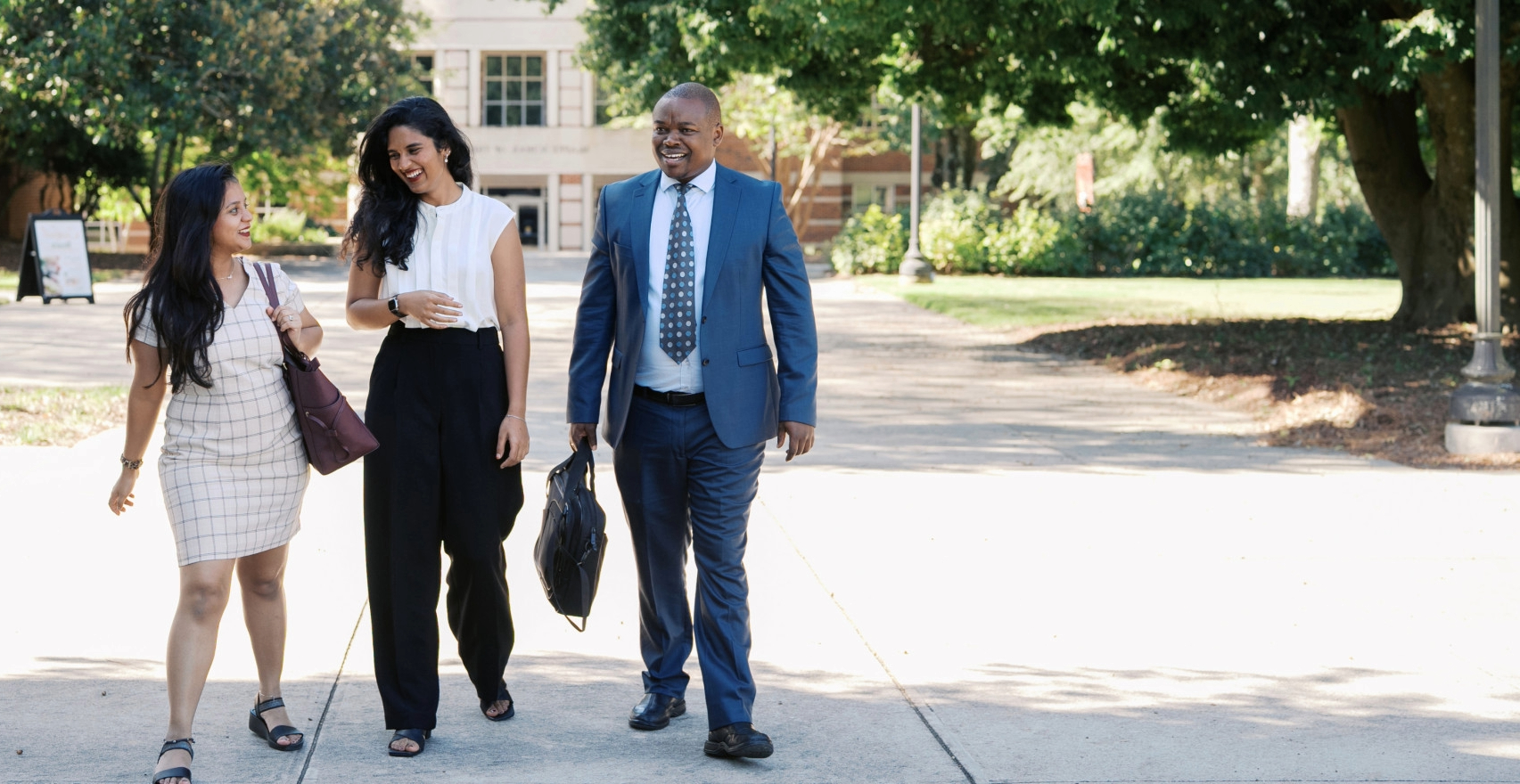 three business students walking together outside