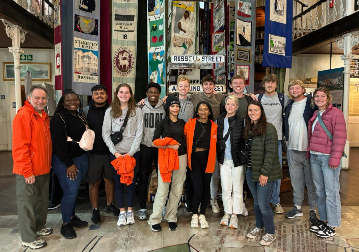 group of students posing in front of a monument inside a museum